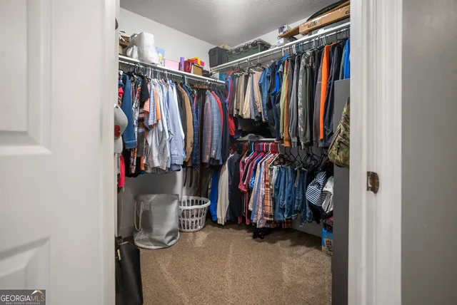 a view of walk in closet with clothes