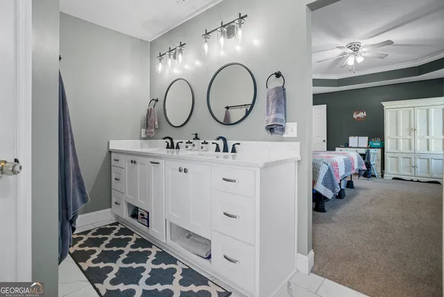 a en suite bathroom with a double vanity sink and a mirror