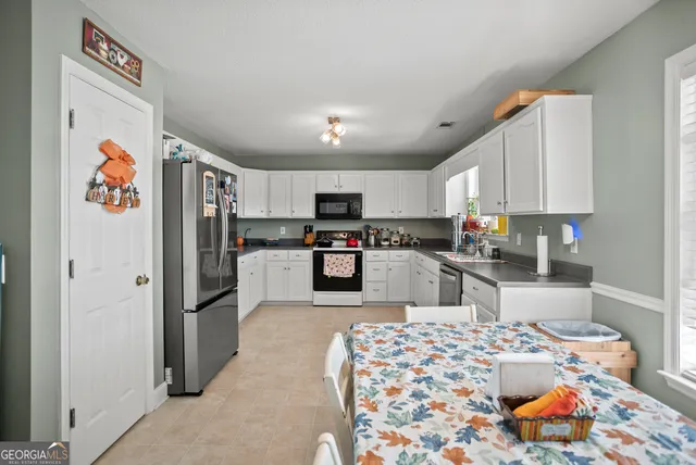 a kitchen with stainless steel appliances granite countertop a refrigerator and a stove top oven