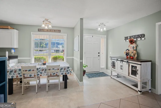 a view of a dining room with furniture and chandelier