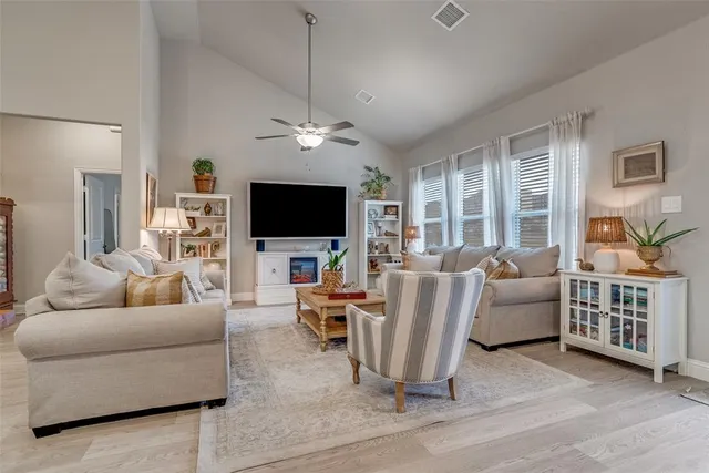 a living room with furniture a flat screen tv and a chandelier