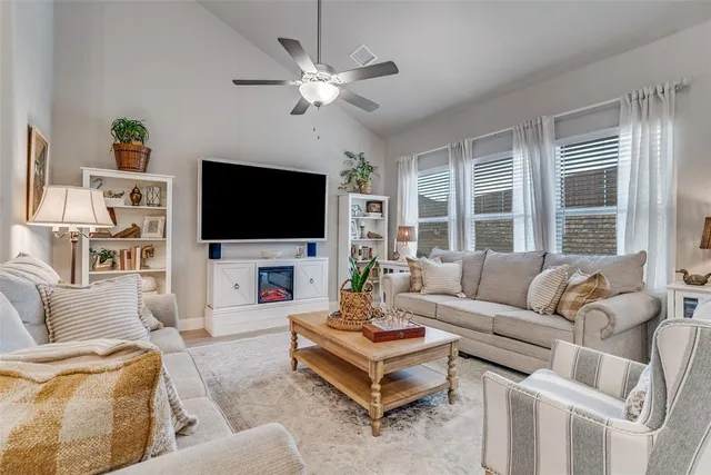 a living room with furniture a flat screen tv and a large window