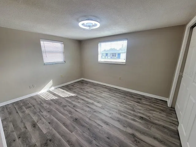 a view of empty room with wooden floor