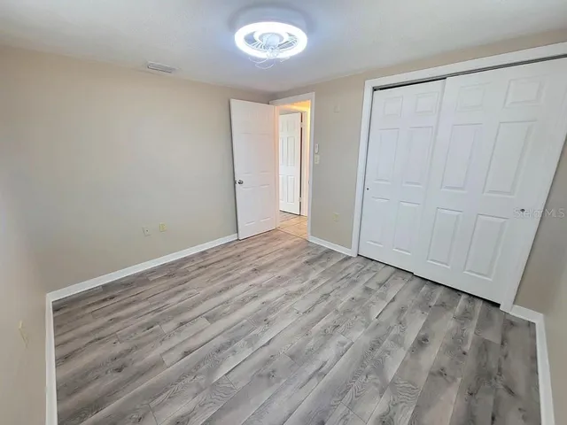 a view of an empty room with wooden floor