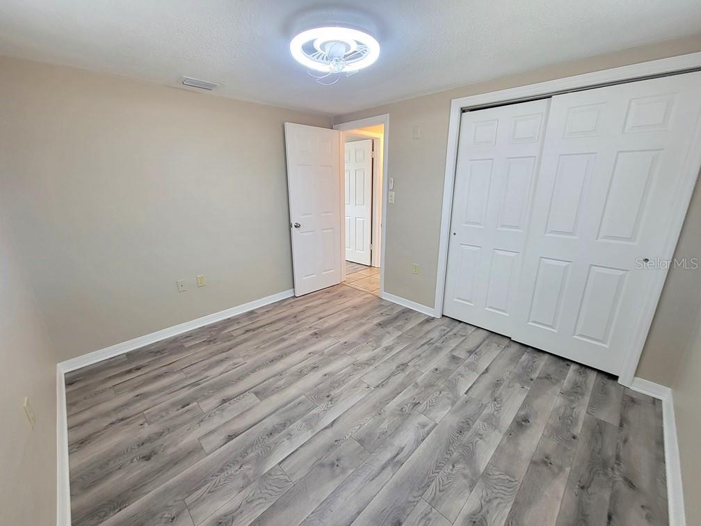 7335 Castanea Drive Port Richey, FL 34668 - Photo 15 of 20 a view of an empty room with wooden floor