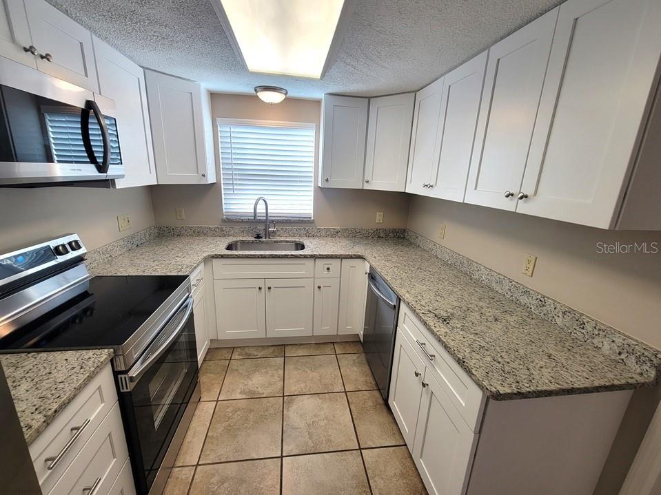 7335 Castanea Drive Port Richey, FL 34668 - Photo 10 of 20 a kitchen with a sink stove top oven and cabinets