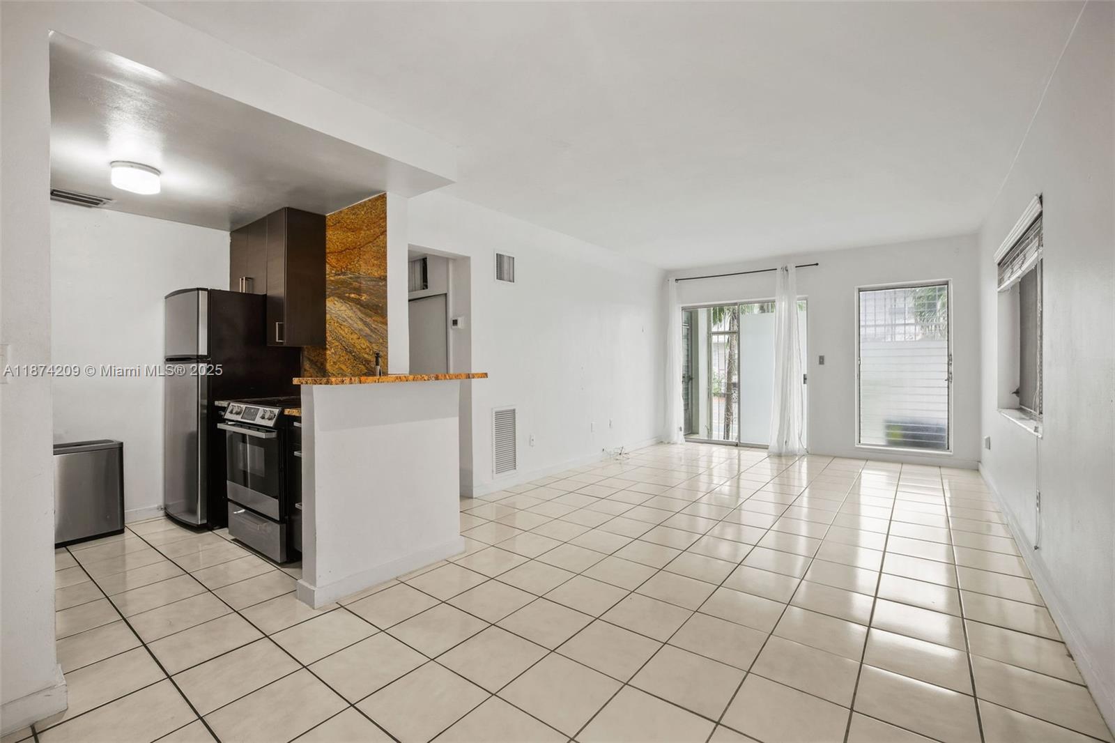 641 Española Way, Unit 3 Miami Beach, FL 33139 - Photo 3 of 23 a view of a refrigerator in kitchen and empty room with windows