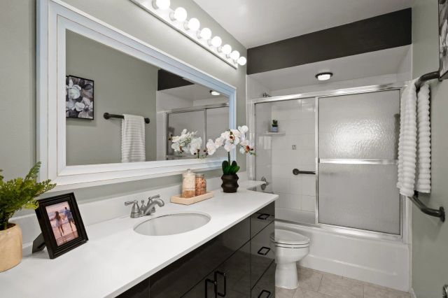 a bathroom with a sink a toilet and shower