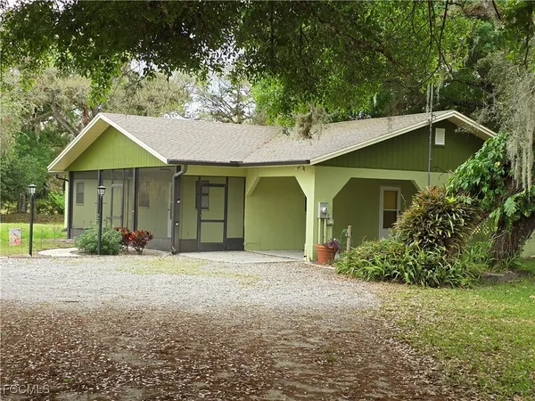 a front view of a house with a garden and trees
