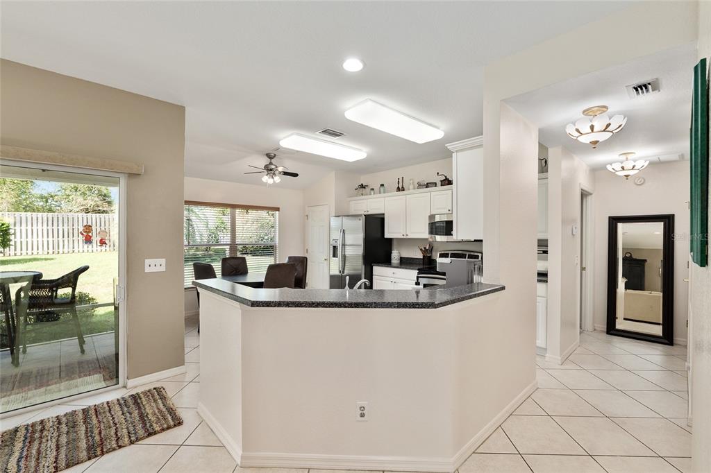 9063 Southeast 120th Loop Summerfield, FL 34491 - Photo 19 of 90 a view of a kitchen with kitchen island granite countertop a sink and refrigerator