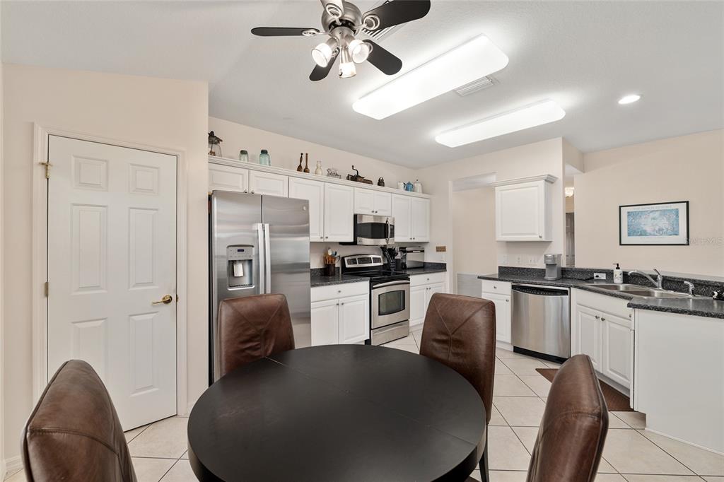 9063 Southeast 120th Loop Summerfield, FL 34491 - Photo 27 of 90 a kitchen with stainless steel appliances granite countertop a refrigerator a stove a sink dishwasher a dining table and chairs with wooden floor