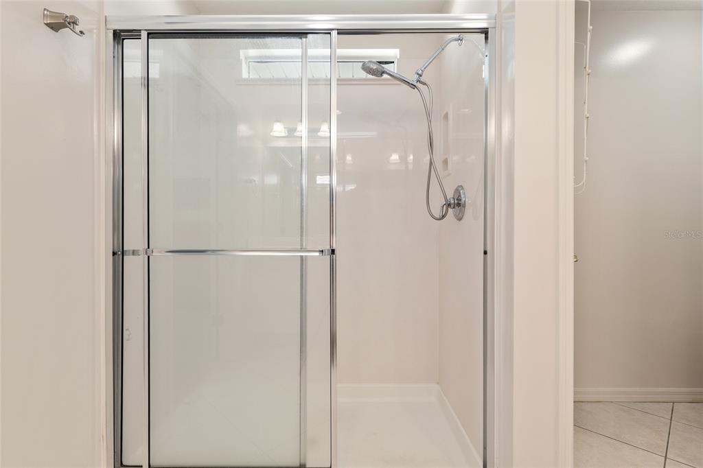 9063 Southeast 120th Loop Summerfield, FL 34491 - Photo 34 of 90 a bathroom with a glass shower door