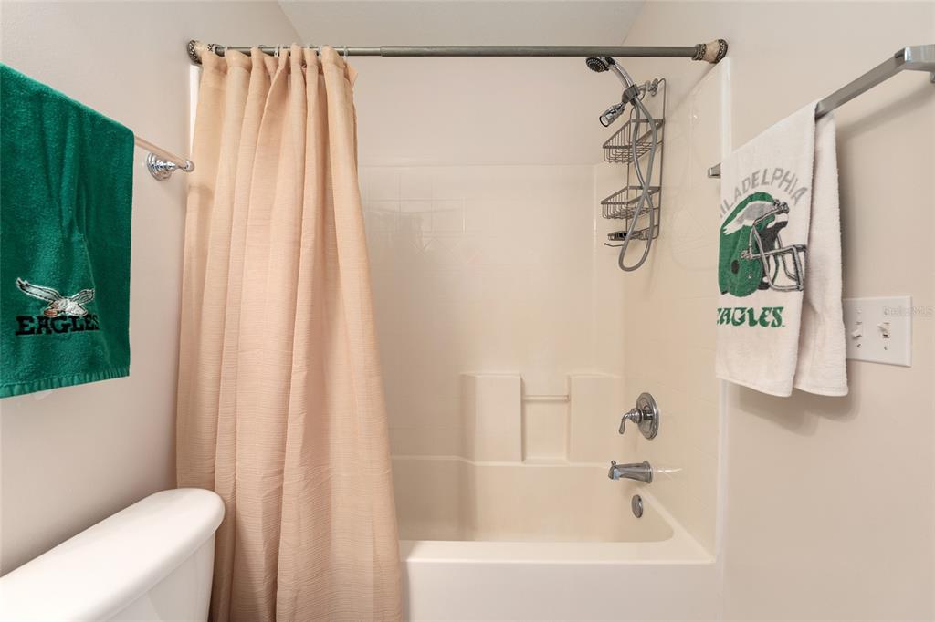 9063 Southeast 120th Loop Summerfield, FL 34491 - Photo 41 of 90 a bathroom with a shower curtain and a bathtub