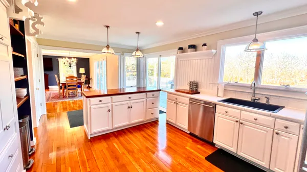 a bedroom with a bed a flat screen tv and dresser next to a window