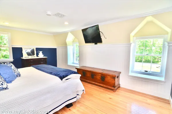 a bedroom with a bed and a dresser next to a window