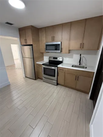 a kitchen with stainless steel appliances a refrigerator sink and microwave