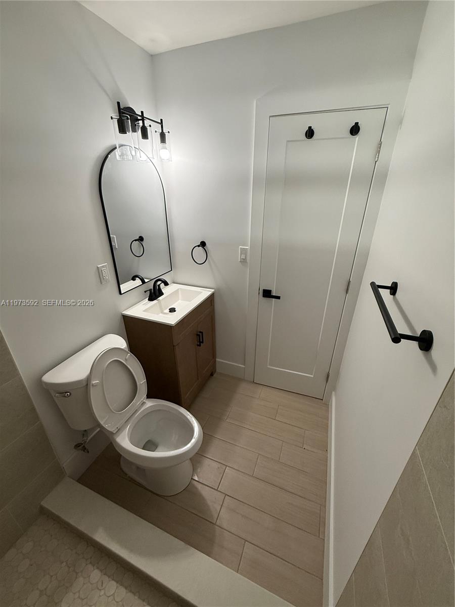 11063 Southwest 5th Street, Unit 11063 Sweetwater, FL 33174 - Photo 6 of 19 a bathroom with a toilet sink and mirror