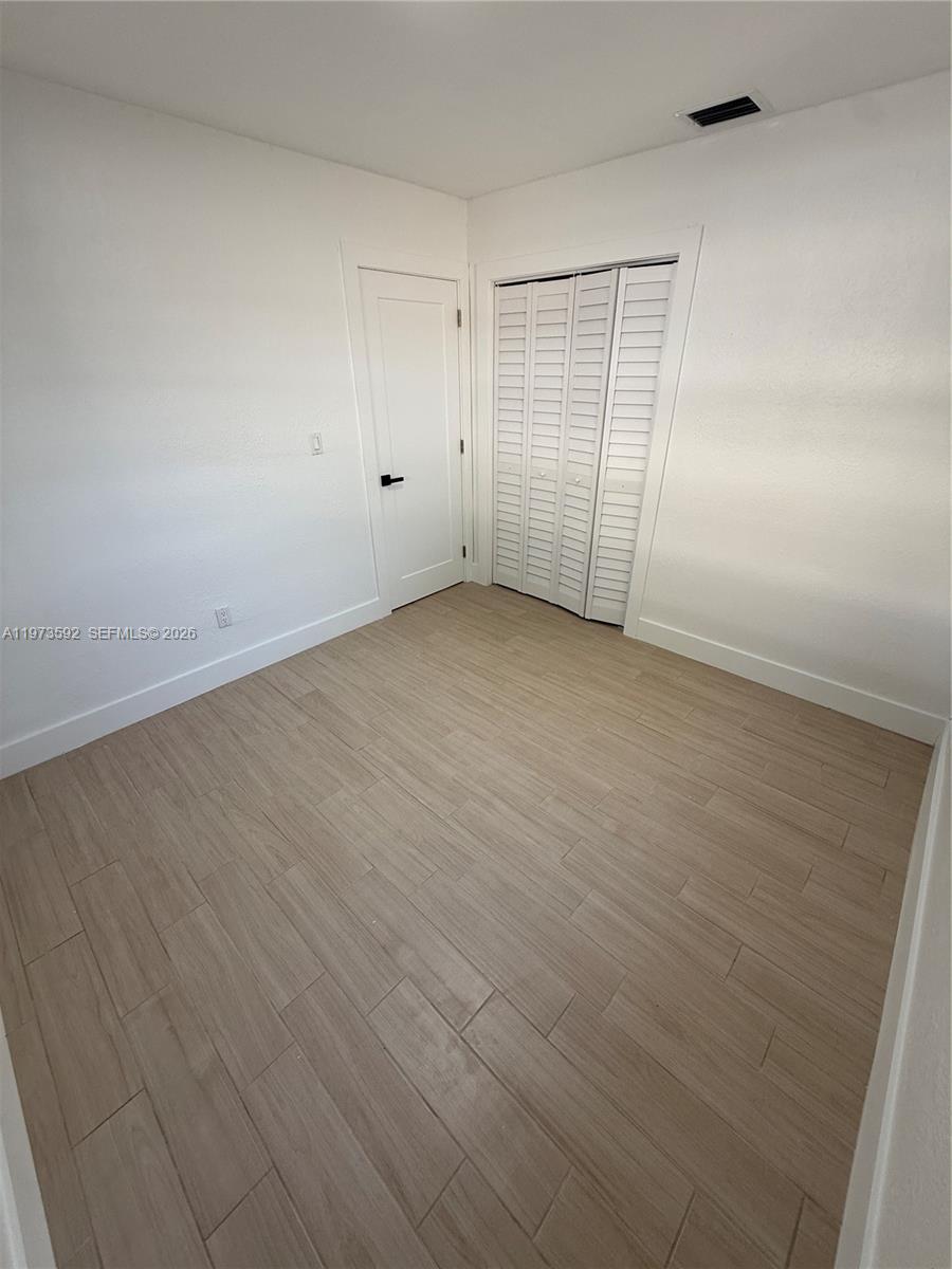 11063 Southwest 5th Street, Unit 11063 Sweetwater, FL 33174 - Photo 10 of 19 a view of an empty room with wooden floor