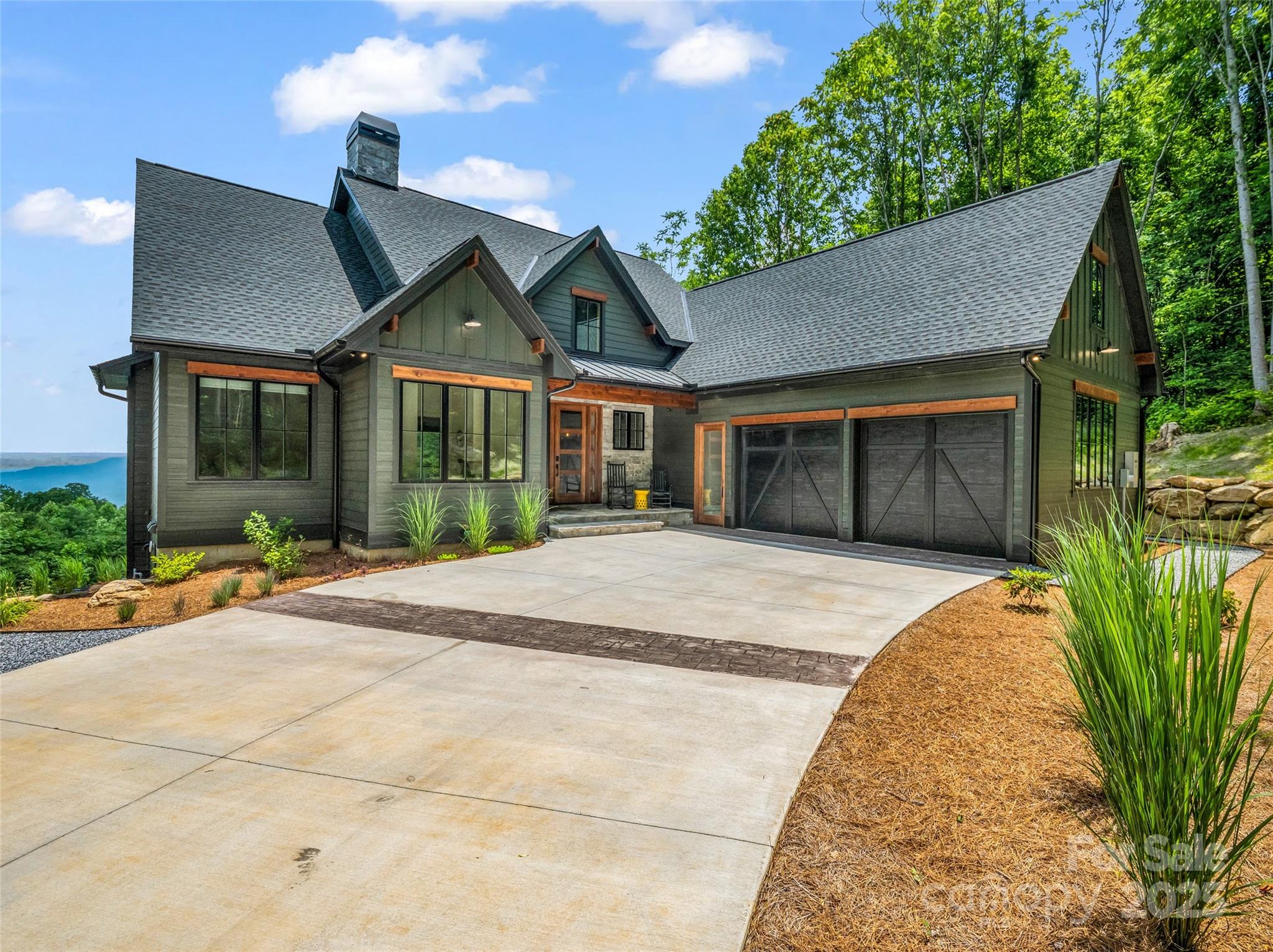 a front view of a house with a yard and potted plants