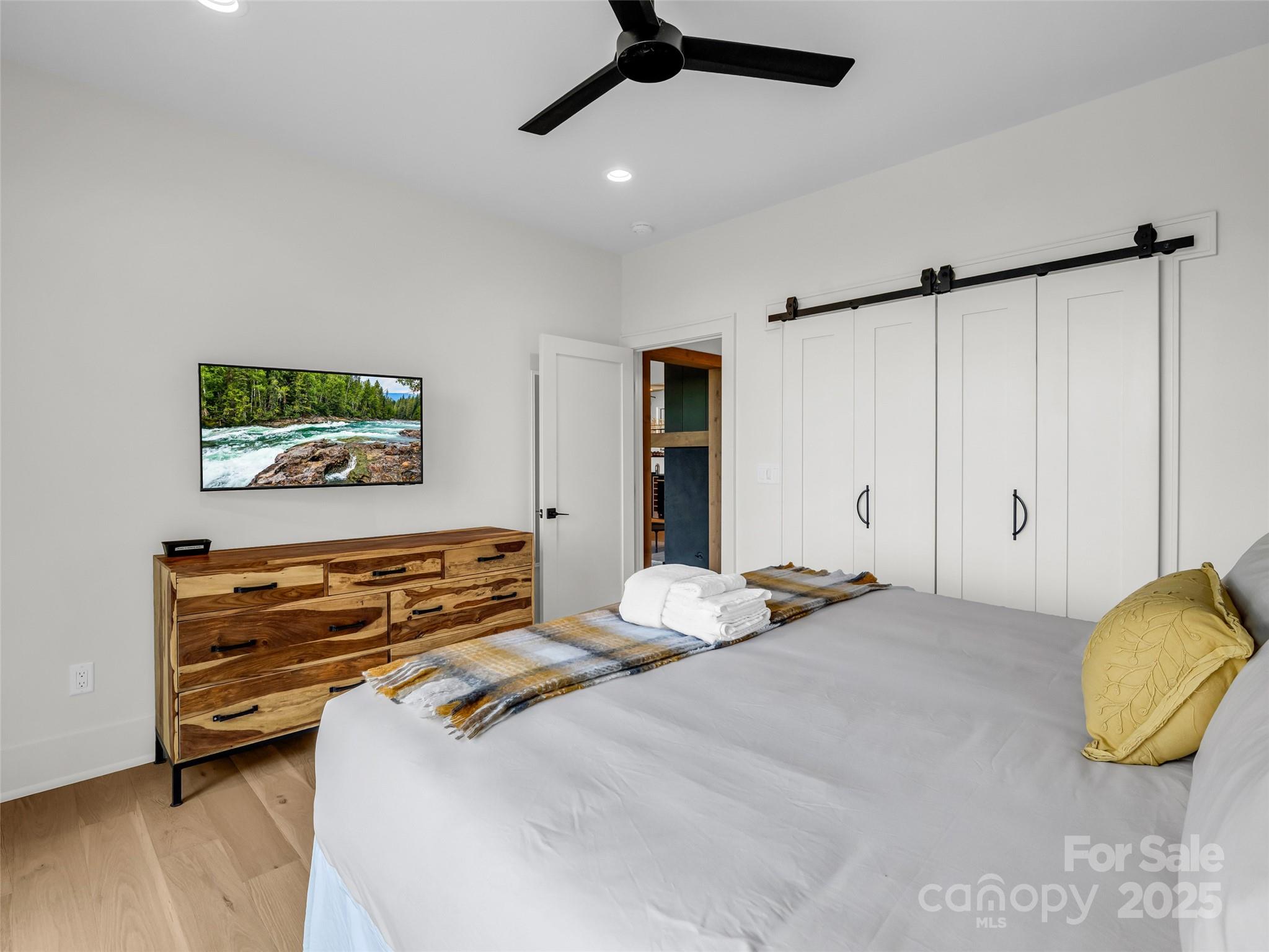 627 Cherry Hill, Unit 201 Mill Spring, NC 28756 - Photo 19 of 48 a bedroom with a bed and a chandelier