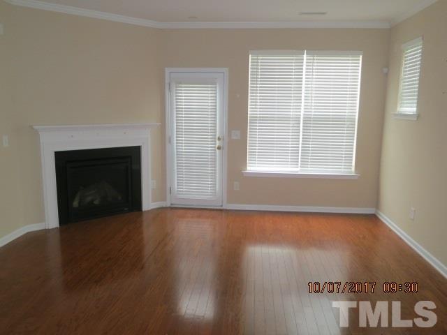 2969 Casona Way Raleigh, NC 27616 - Photo 5 of 7 a view of an empty room with wooden floor fireplace and a window