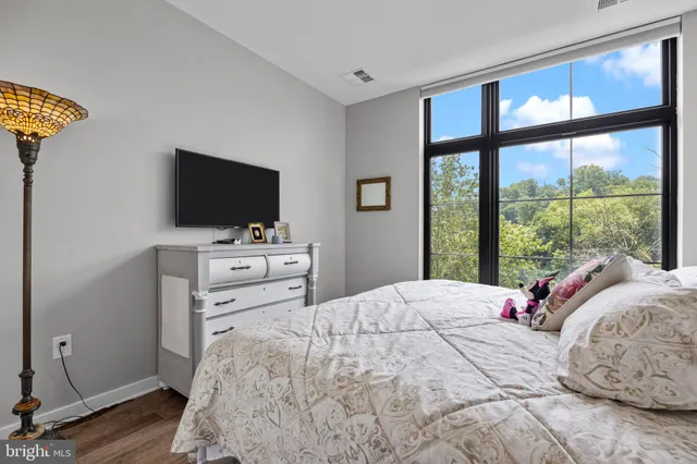 a bedroom with a bed and a flat tv screen on the dresser