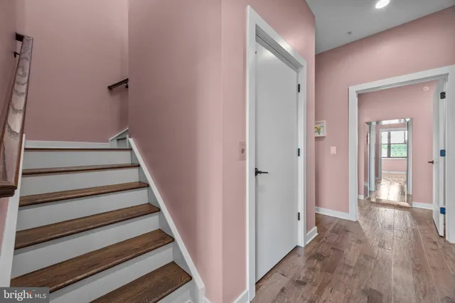 a view of a hallway with wooden floor and entryway