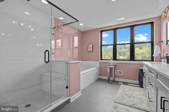 a bathroom with a tub sink shower and mirror