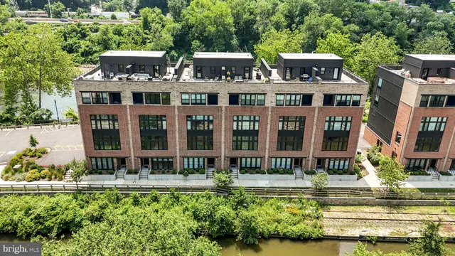 an aerial view of residential houses with outdoor space and river