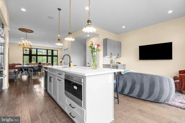a kitchen with stainless steel appliances granite countertop a stove and a wooden floors