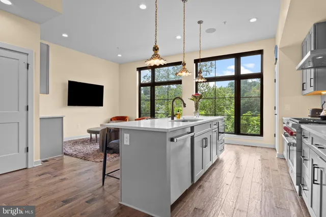 a open kitchen with stainless steel appliances granite countertop a stove and a large window