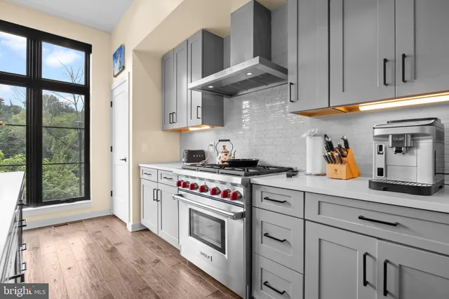 a kitchen with stainless steel appliances granite countertop a stove and a white cabinets