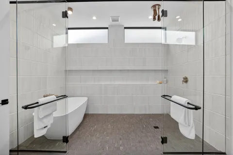 a bathroom with a double vanity sink a mirror and a bathtub