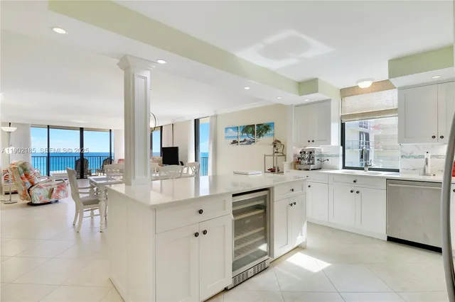 a large white kitchen with a lot of counter space and wooden floor