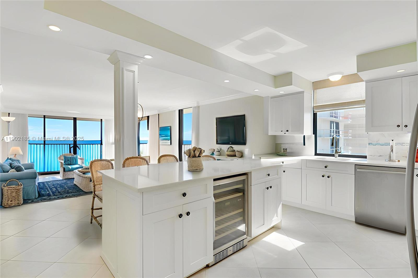 200 South Beach Road, Unit 703 Tequesta, FL 33469 - Photo 29 of 52 a large white kitchen with a stove a sink dishwasher and a microwave oven with white cabinets