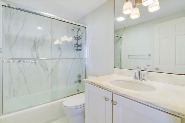 a bathroom with a granite countertop sink a toilet and a mirror