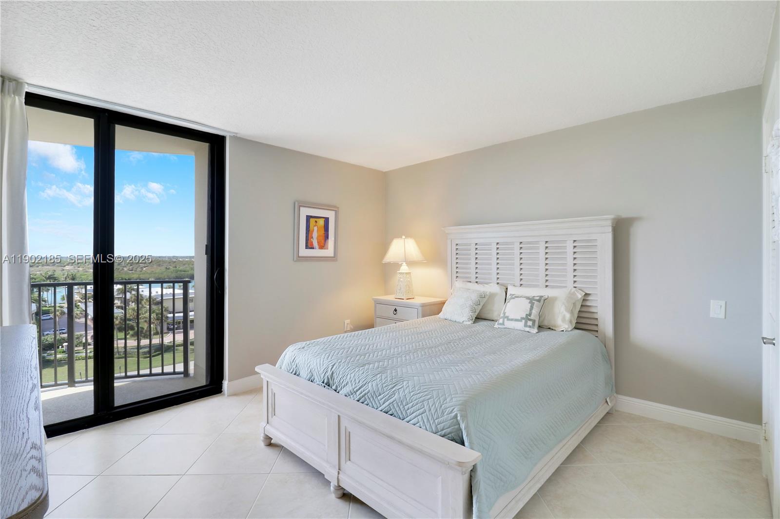 200 South Beach Road, Unit 703 Tequesta, FL 33469 - Photo 9 of 52 a bedroom with a large bed and a window