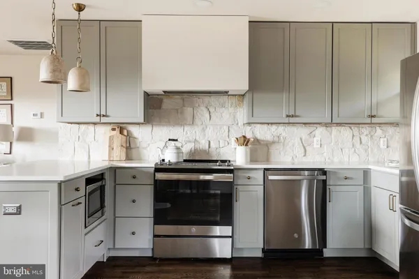 a kitchen with stainless steel appliances granite countertop a sink and a stove