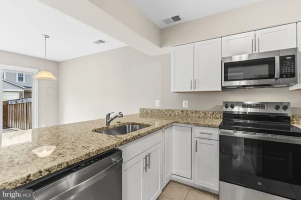 a kitchen with stainless steel appliances granite countertop a sink stove oven a sink and dishwasher a refrigerator with wooden cabinets