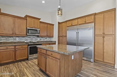 a kitchen with kitchen island granite countertop cabinets and stainless steel appliances