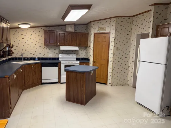 a kitchen with stainless steel appliances granite countertop a refrigerator a stove a sink and a microwave