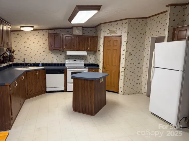 a kitchen with stainless steel appliances granite countertop a refrigerator a stove a sink and a microwave