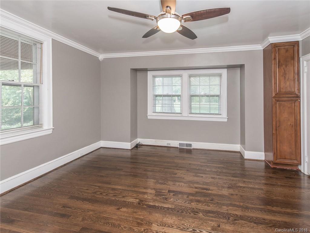 2711 Providence Road Charlotte, NC 28211 - Photo 20 of 35 an empty room with wooden floor chandelier fan and windows