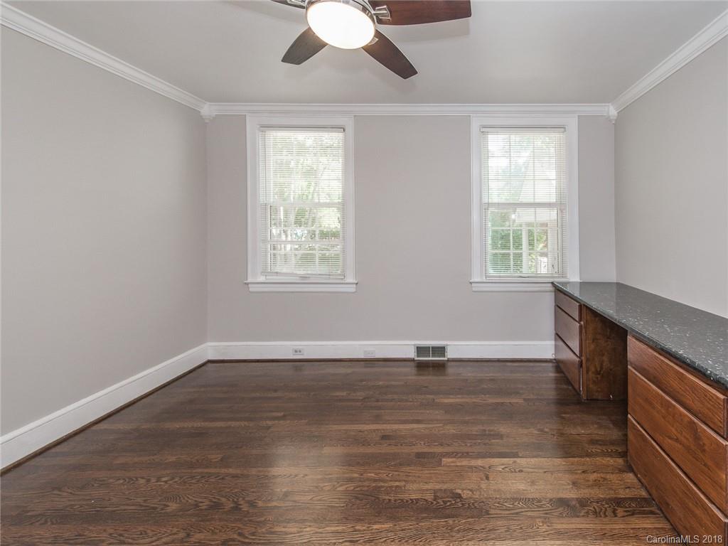 2711 Providence Road Charlotte, NC 28211 - Photo 22 of 35 an empty room with wooden floor chandelier fan and windows
