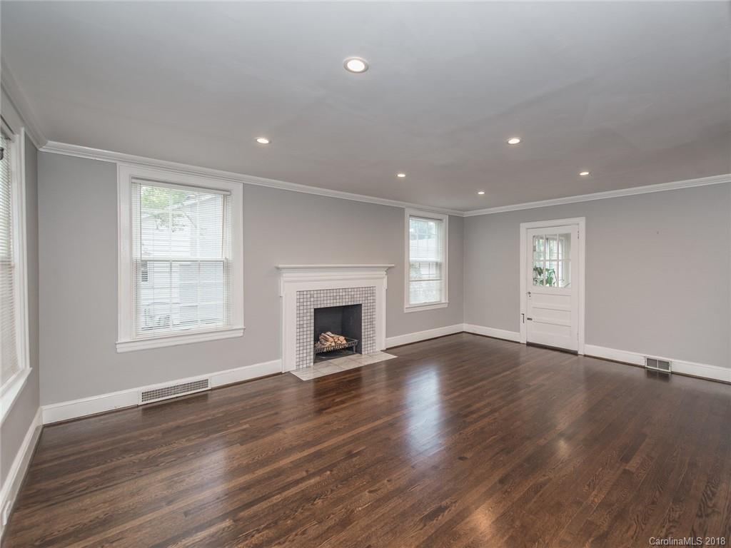 2711 Providence Road Charlotte, NC 28211 - Photo 6 of 35 an empty room with wooden floor fireplace and windows