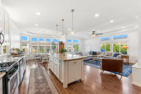 a dining room with furniture a chandelier and wooden floor