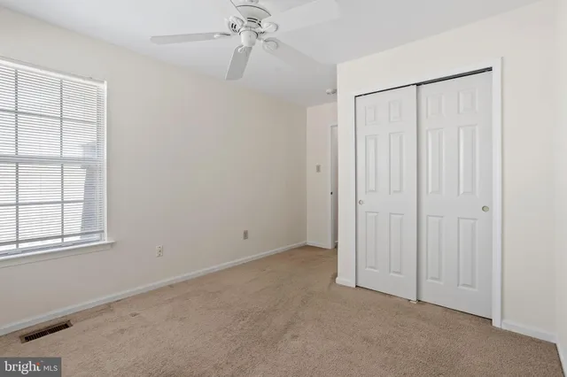 an empty room with windows and closet
