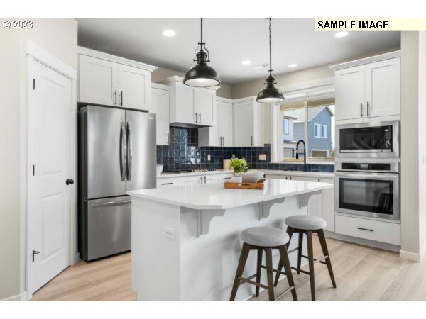 208 South 87th Avenue, Unit 60 Ridgefield, WA 98642 - Photo 2 of 32 a kitchen with stainless steel appliances a refrigerator a stove a sink and chairs