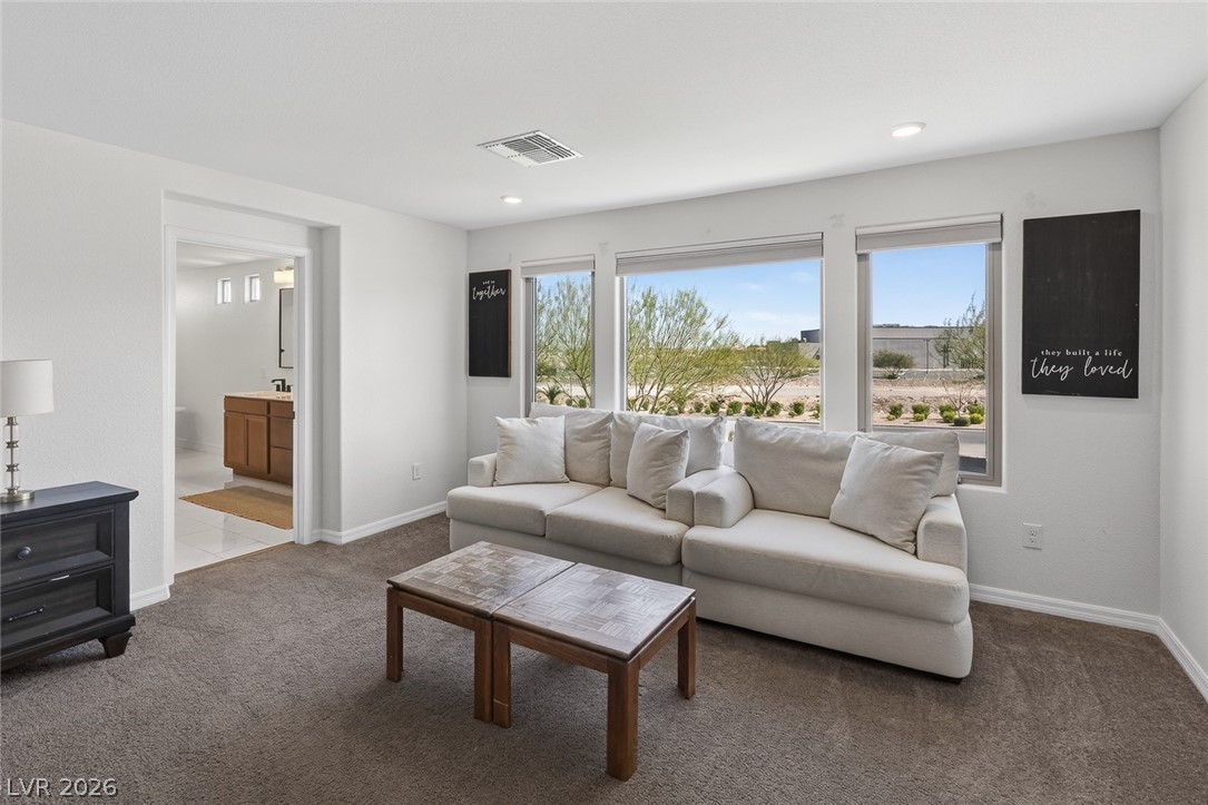 10446 Emerald Rye Street Las Vegas, NV 89183 - Photo 21 of 37 A versatile living area with a plush sectional sofa, ample natural light, and a clear sightline to an adjacent bath.
