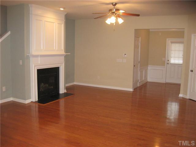 7025 Racine Way Raleigh, NC 27615 - Photo 3 of 7 The sleek hardwoods extend throughout the first floor, The gas fireplace, extra trimwork and recessed lighting add both warmth and style to this great living space.